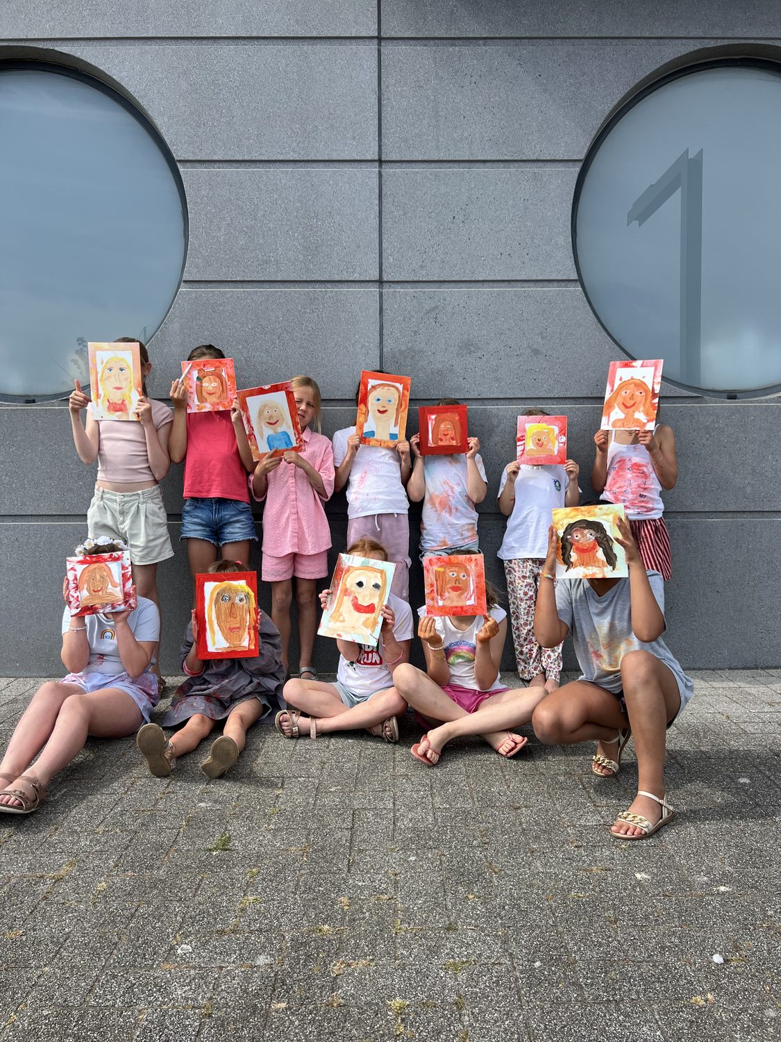 Groepje kinderen toont hun zelfportretten
