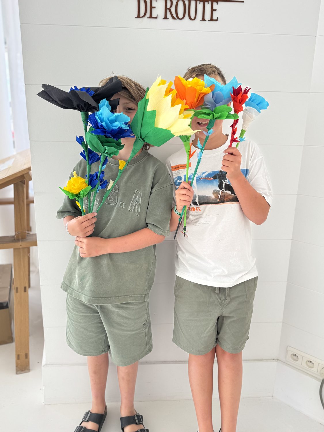 Twee kinderen met zelfgemaakte papieren bloemen